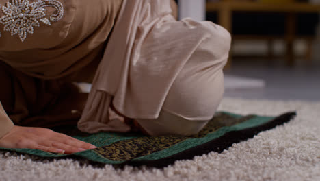 Cerca-De-Una-Mujer-Musulmana-Usando-Hijab-En-Casa-Orando-Arrodillada-Sobre-Una-Alfombra-De-Oración-7